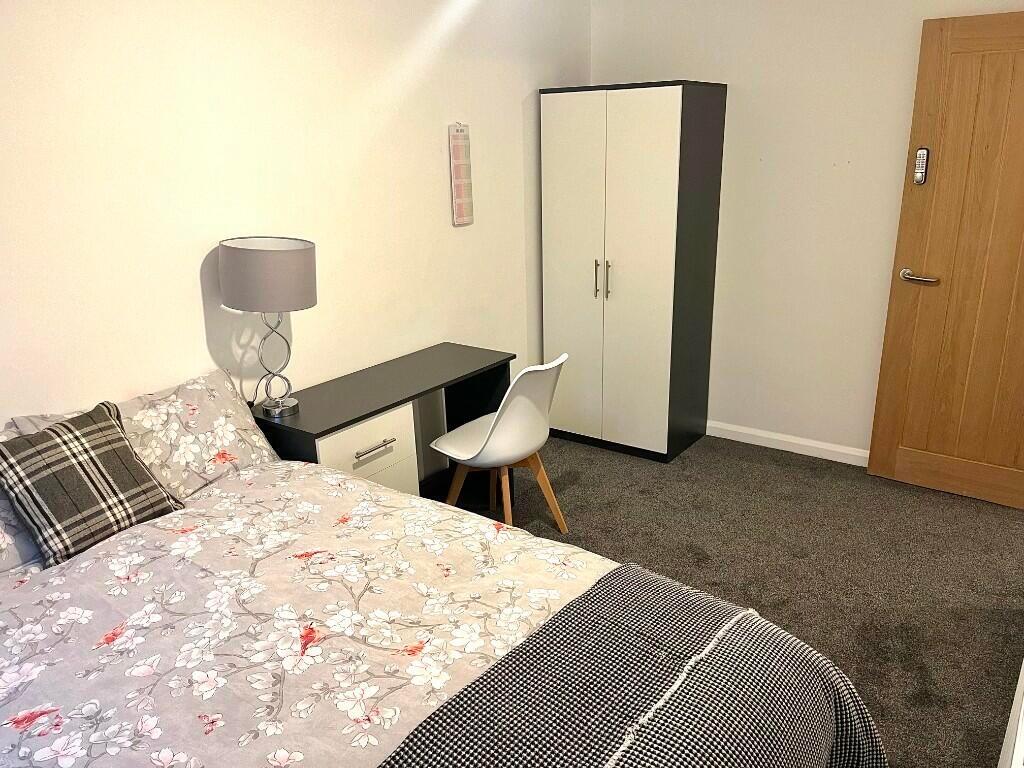 A neat and comfortable single bedroom featuring...