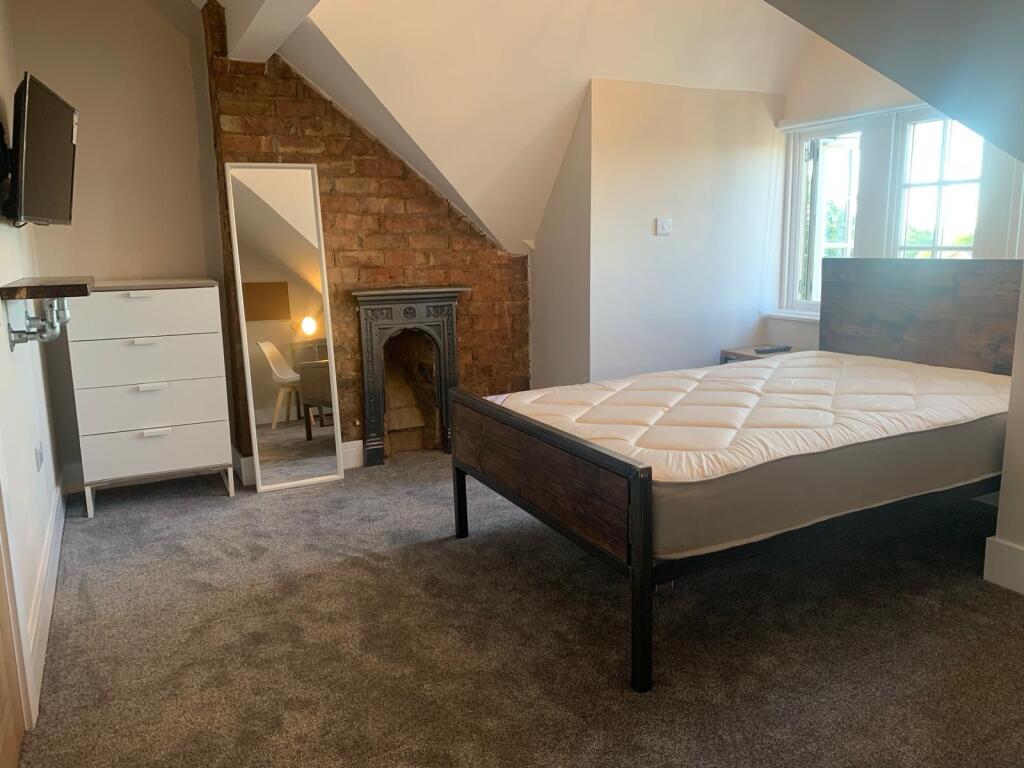 Spacious and well-lit bedroom featuring a sturd...