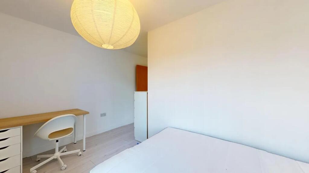 A bright and tidy single bedroom featuring a si...