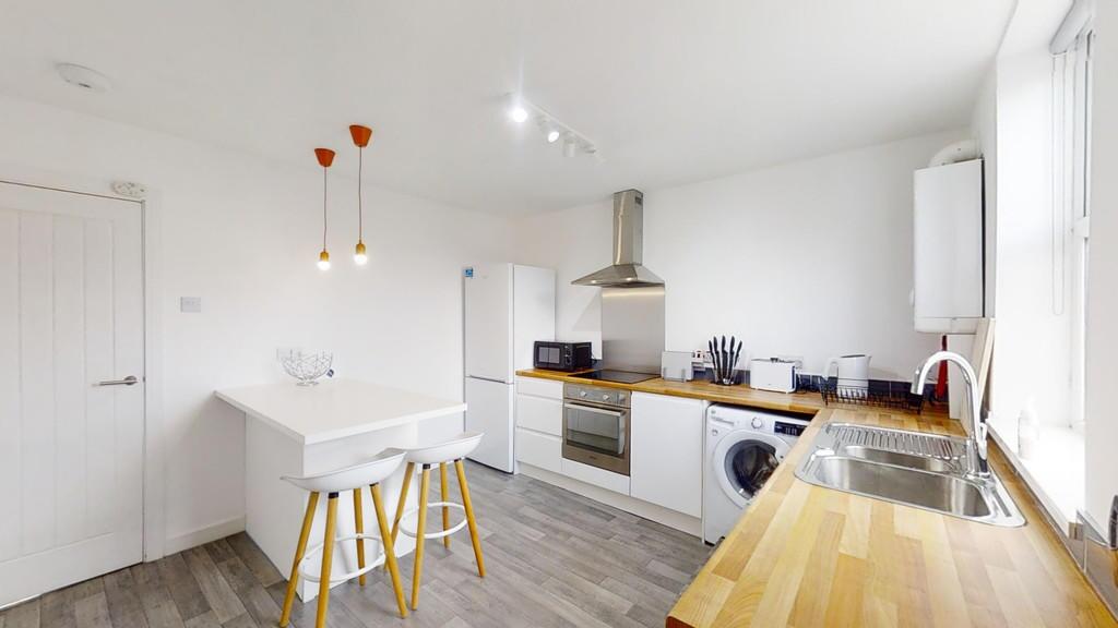 A bright and modern kitchen featuring clean whi...