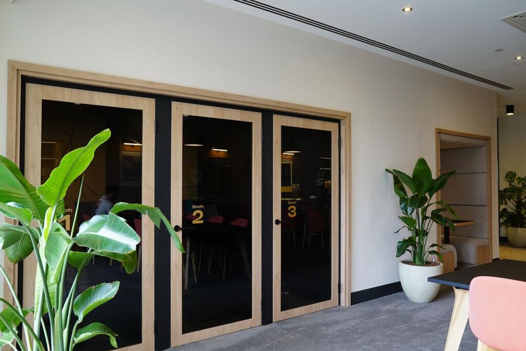 Modern communal workspace featuring private num...