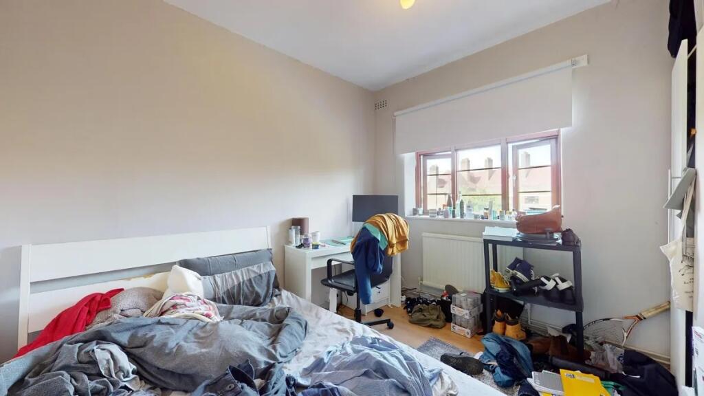 A bright double bedroom featuring a comfortable...