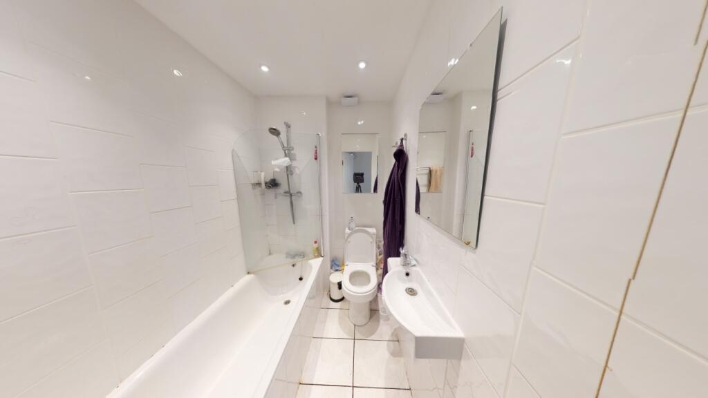 Bright and modern bathroom suite featuring a fu...
