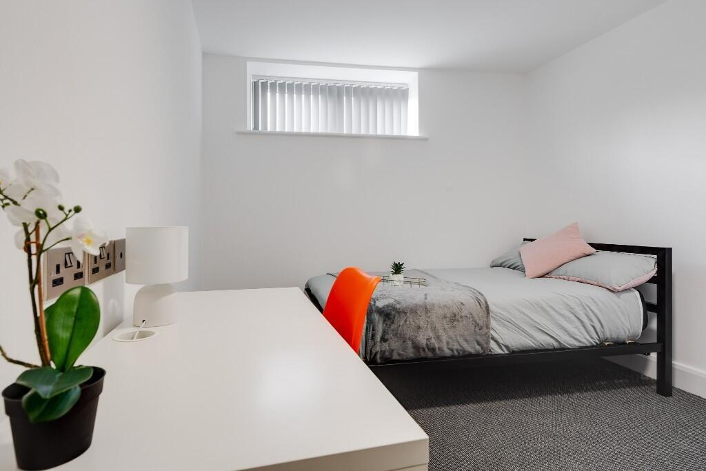 This cozy double bedroom features a comfortable...