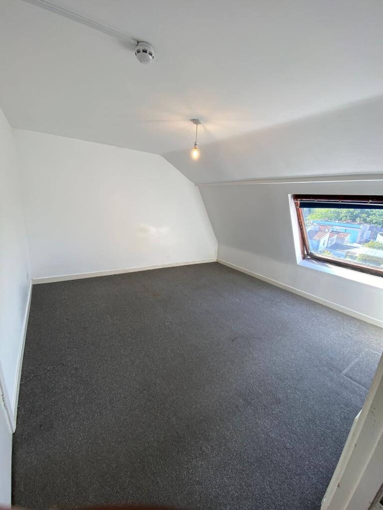 A simple, clean single bedroom featuring a larg...