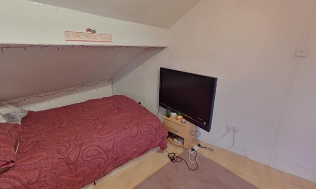 Cozy single bedroom featuring a comfortable bed...
