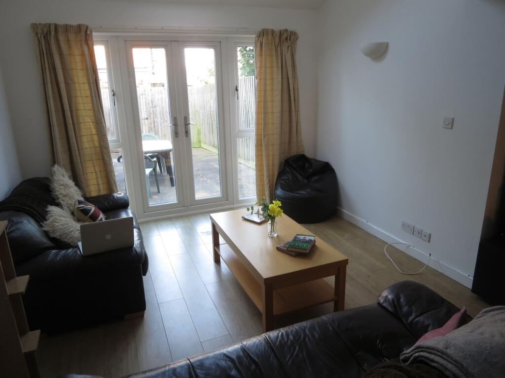 Bright and welcoming living room with large gla...