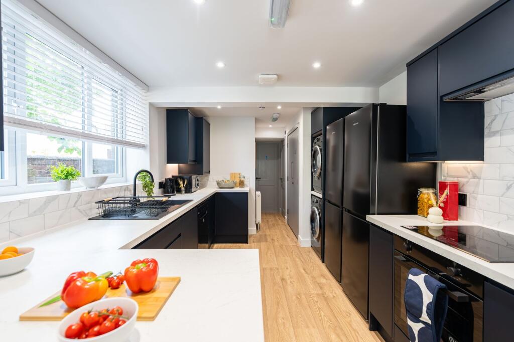 Modern and stylish kitchen featuring sleek dark...