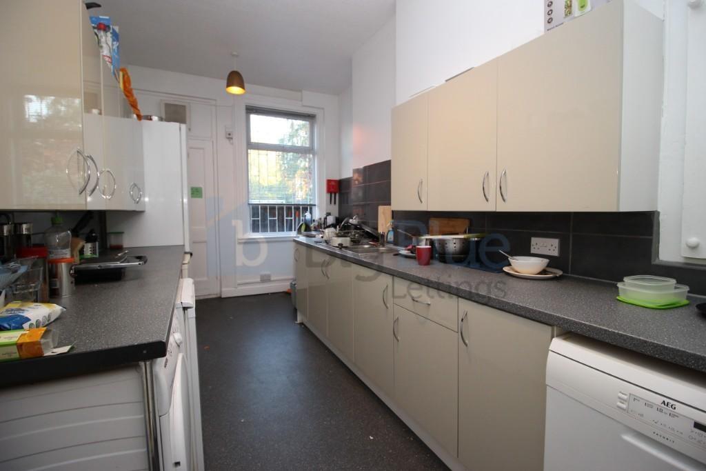 A long, narrow kitchen featuring ample cabinetr...