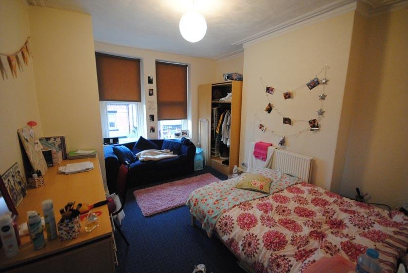 Bright, neatly arranged double bedroom with a c...