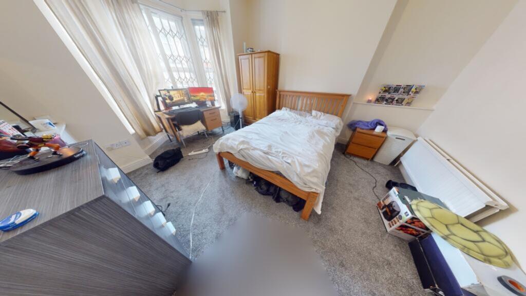 A spacious and well-lit double bedroom with a c...