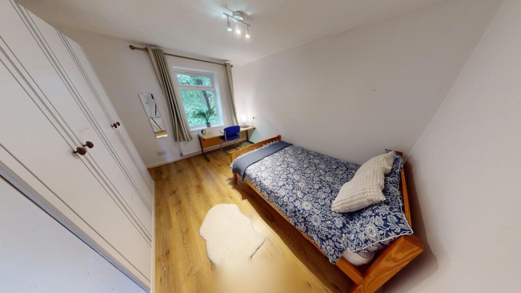 Bright and tidy single bedroom featuring wooden...