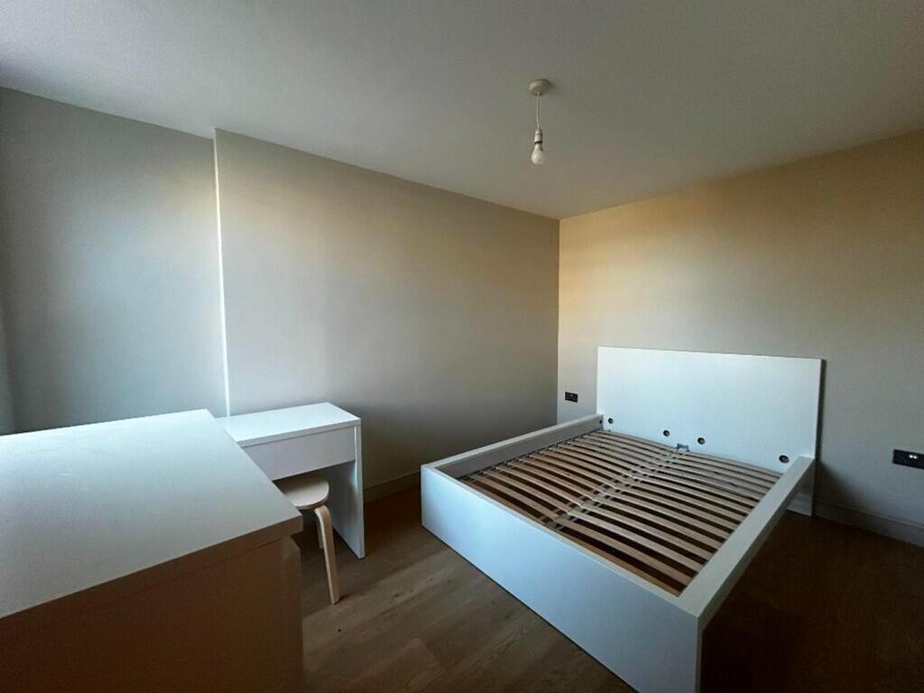 A spacious and bright double bedroom with minim...