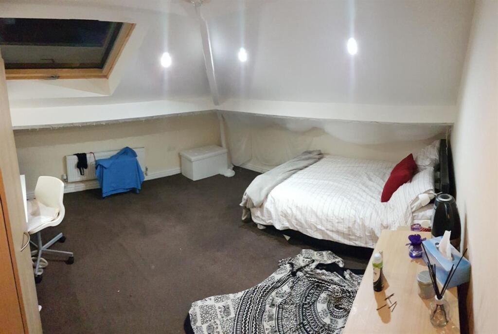 Spacious attic bedroom featuring a comfy double...
