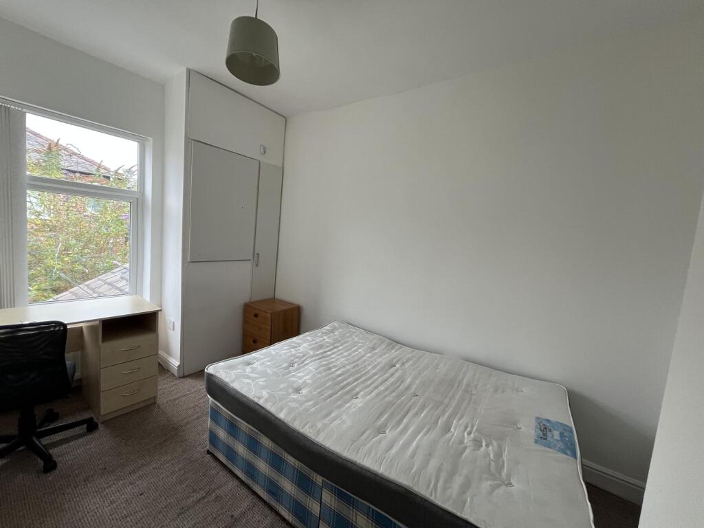 Bright and simple bedroom featuring a large win...