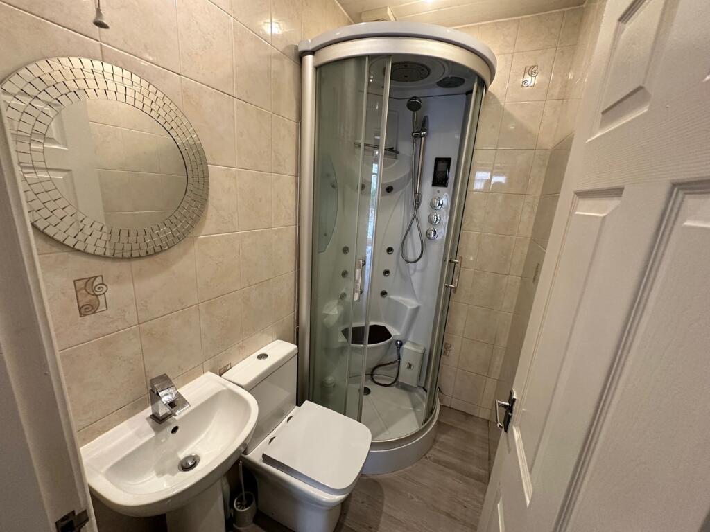 A modern bathroom featuring a sleek shower unit...