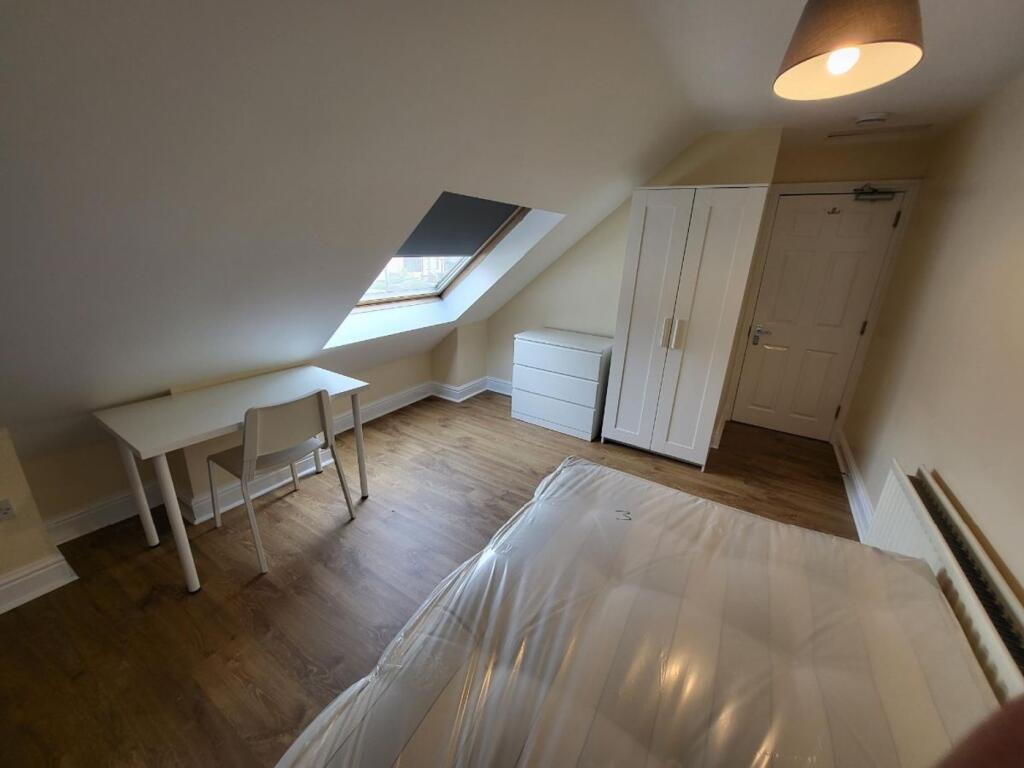 This inviting double bedroom features a cozy la...