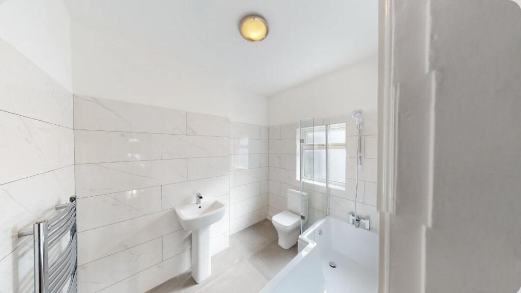 A modern bathroom suite featuring a clean white...