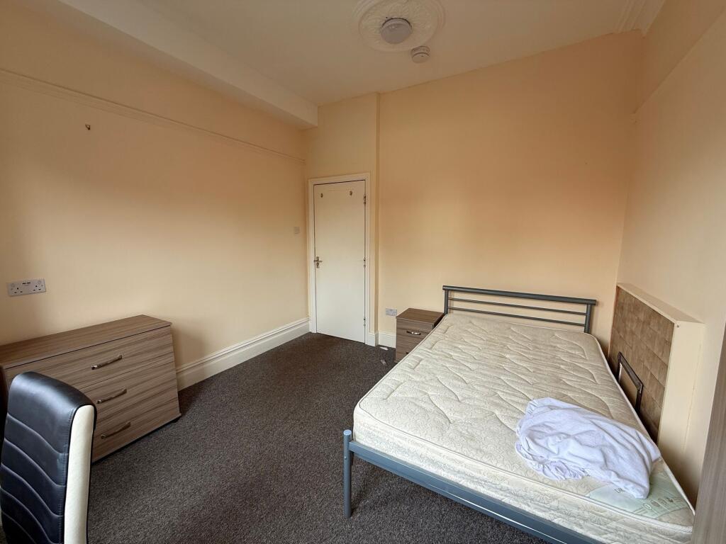 Bright, simply furnished bedroom with a double ...