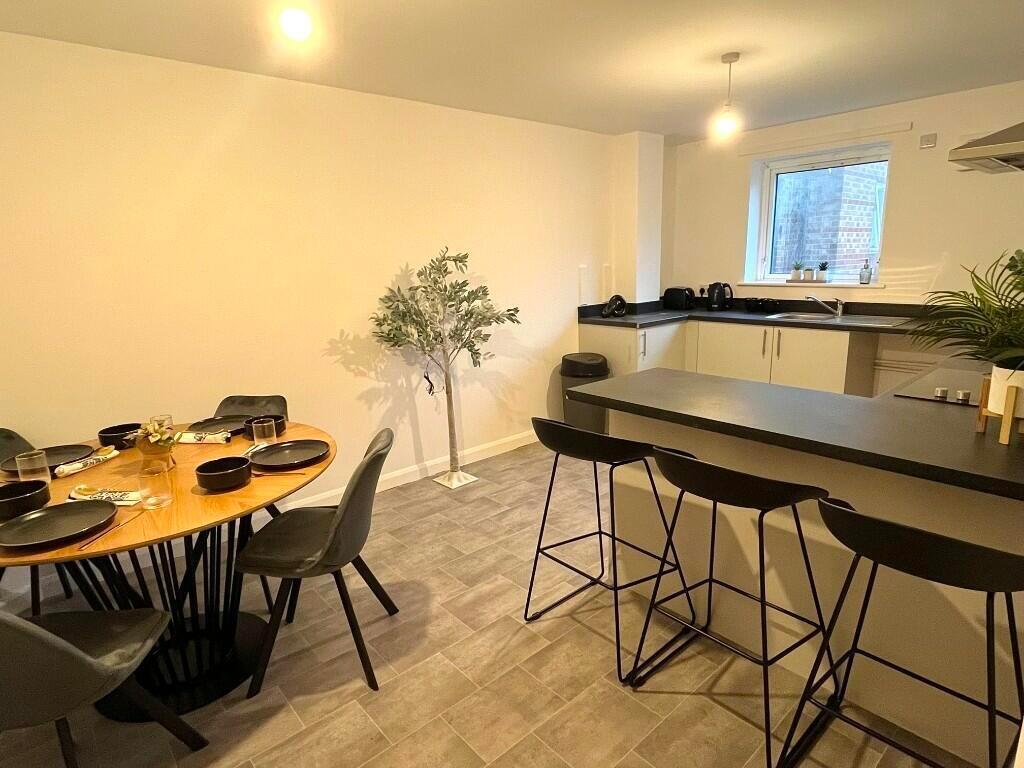 Modern kitchen with sleek black countertops and...