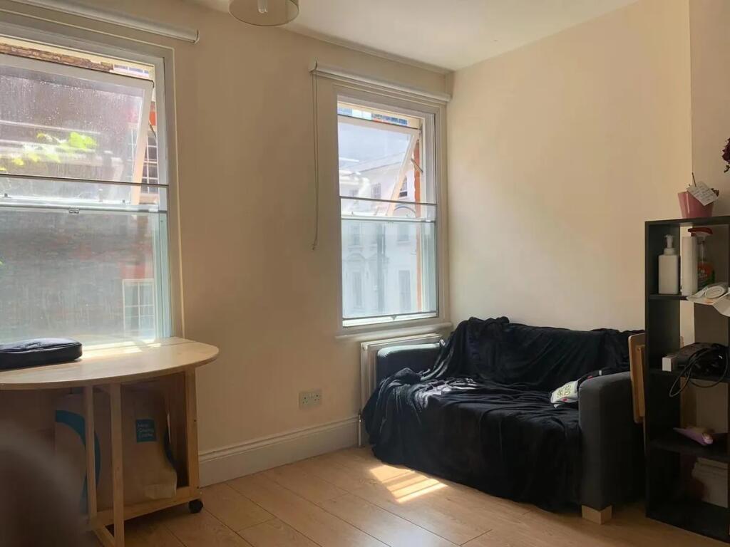 A cozy living room featuring two large windows ...