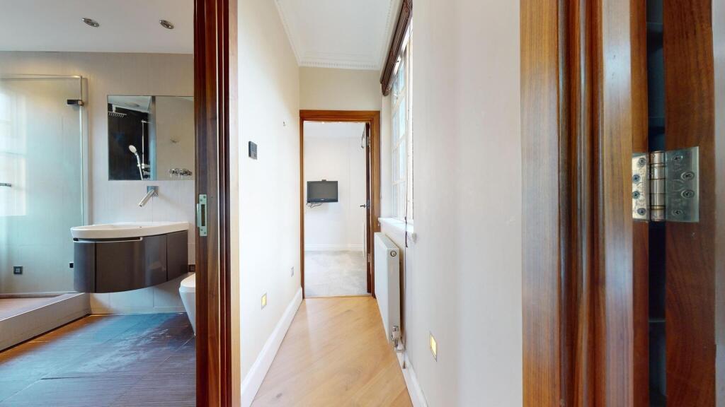 Bright and tidy hallway with wooden flooring an...