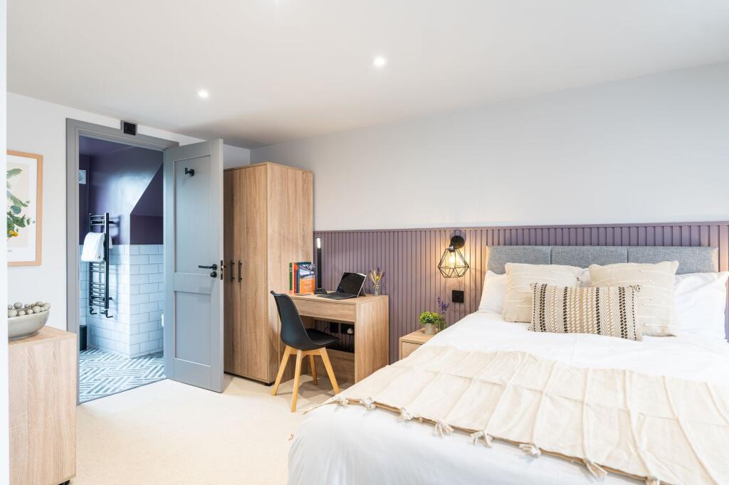 Stylish and inviting master bedroom featuring a...