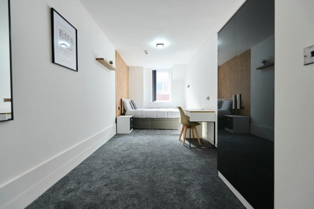 A modern and tidy single bedroom with a comfort...