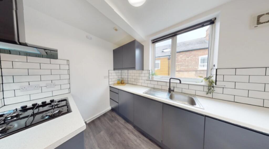 A modern and clean kitchenette with ample natur...