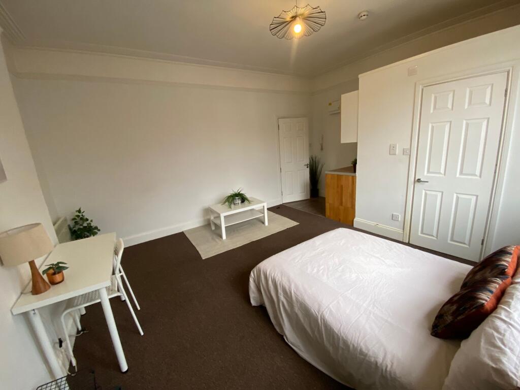A spacious master bedroom featuring a comfortab...