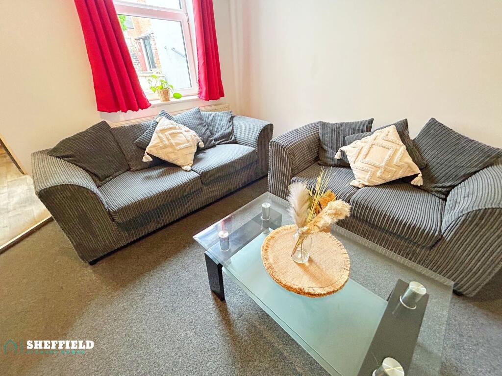 Bright, cosy living room with two comfortable g...