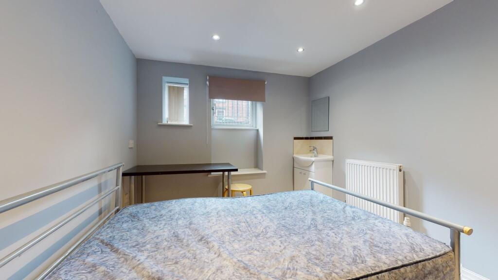 A clean and bright bedroom featuring a bed, a s...