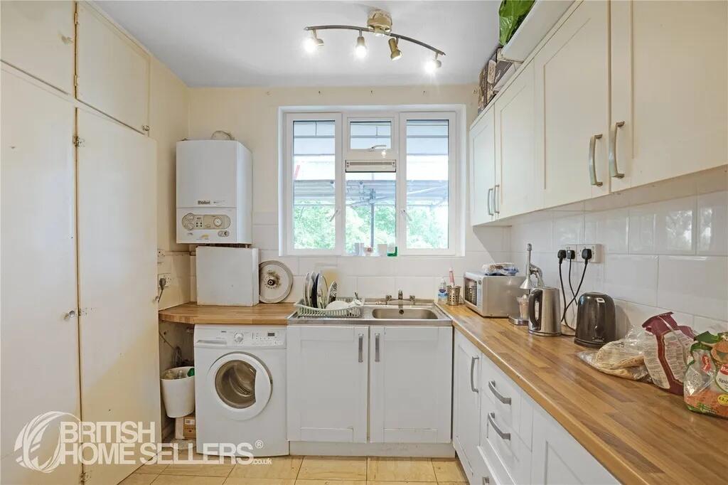 A functional kitchen with a warm wooden counter...
