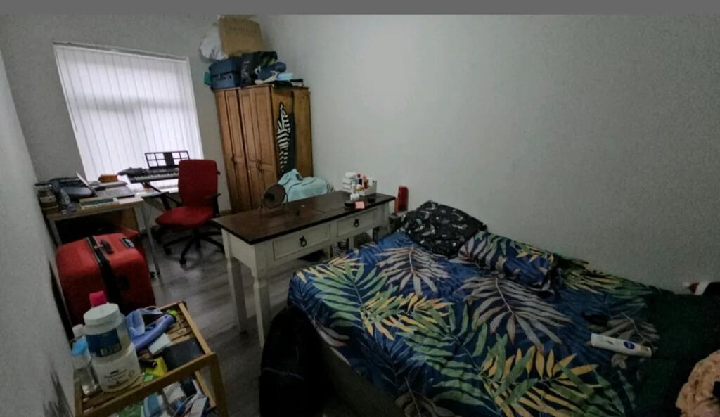 A cozy double bedroom featuring a vibrant tropi...