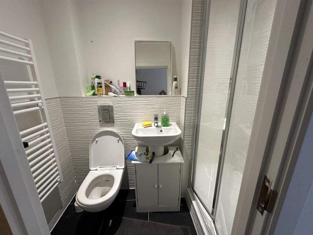 A clean and modern single toilet room featuring...