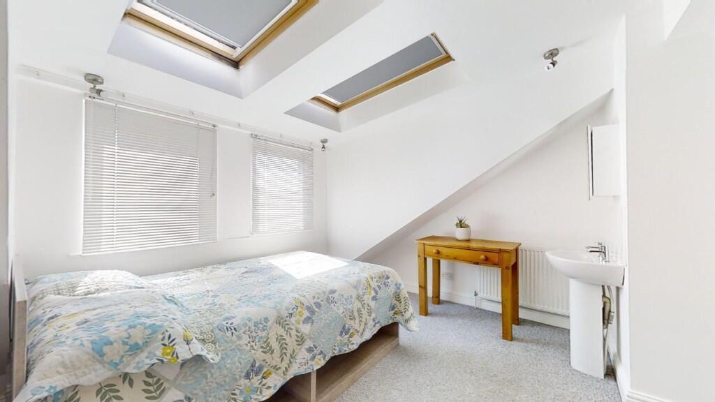 Bright and cozy double bedroom featuring skylig...