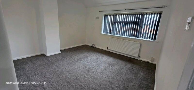 Bright and spacious living room with a large wi...