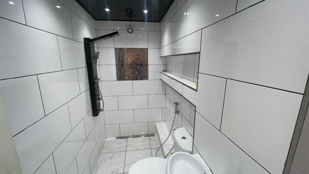 Modern tiled bathroom with a wall-mounted ciste...
