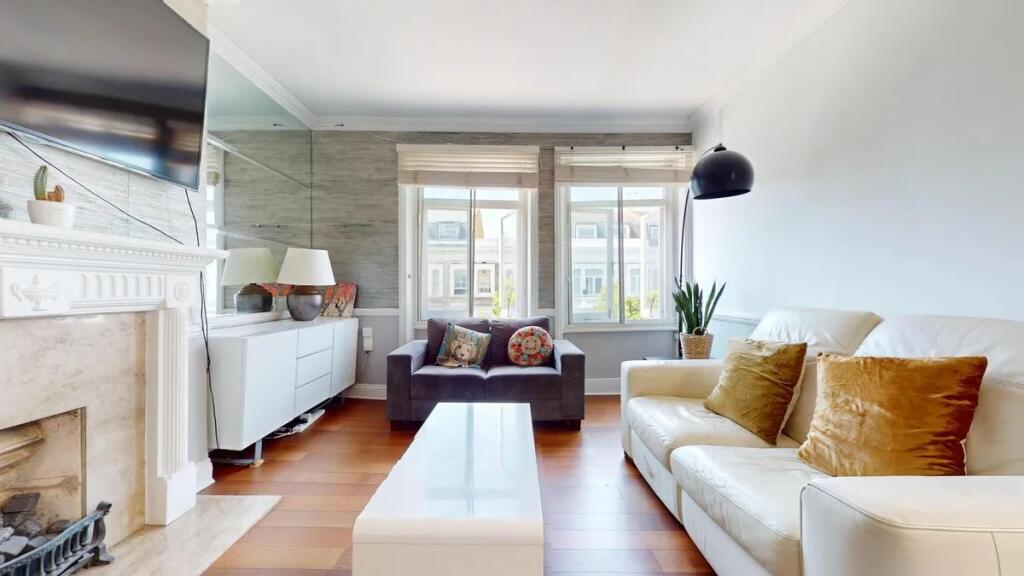 A bright and contemporary living room featuring...