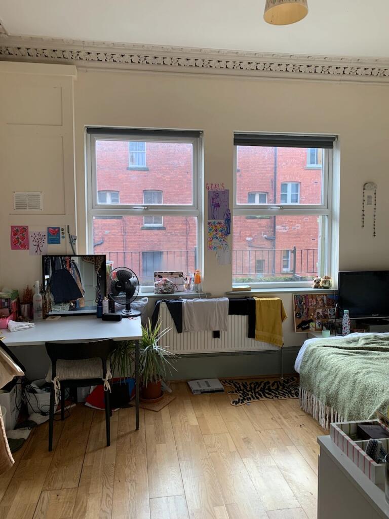 Bright master bedroom featuring large windows t...