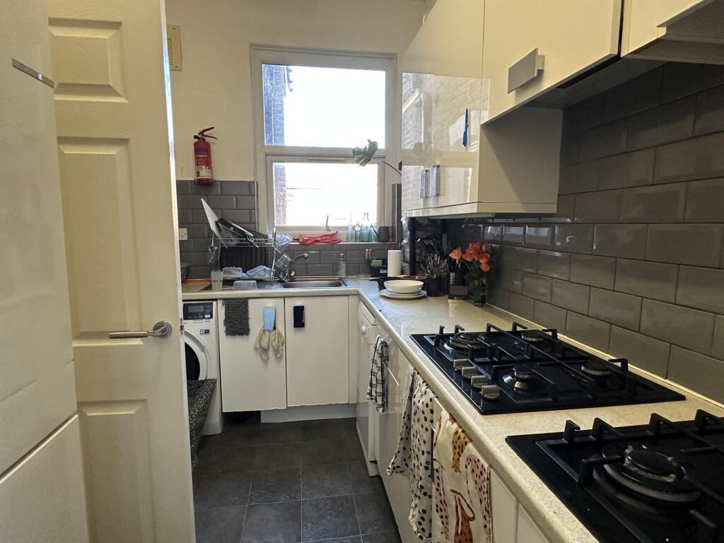 A modern and tidy kitchenette with ample natura...