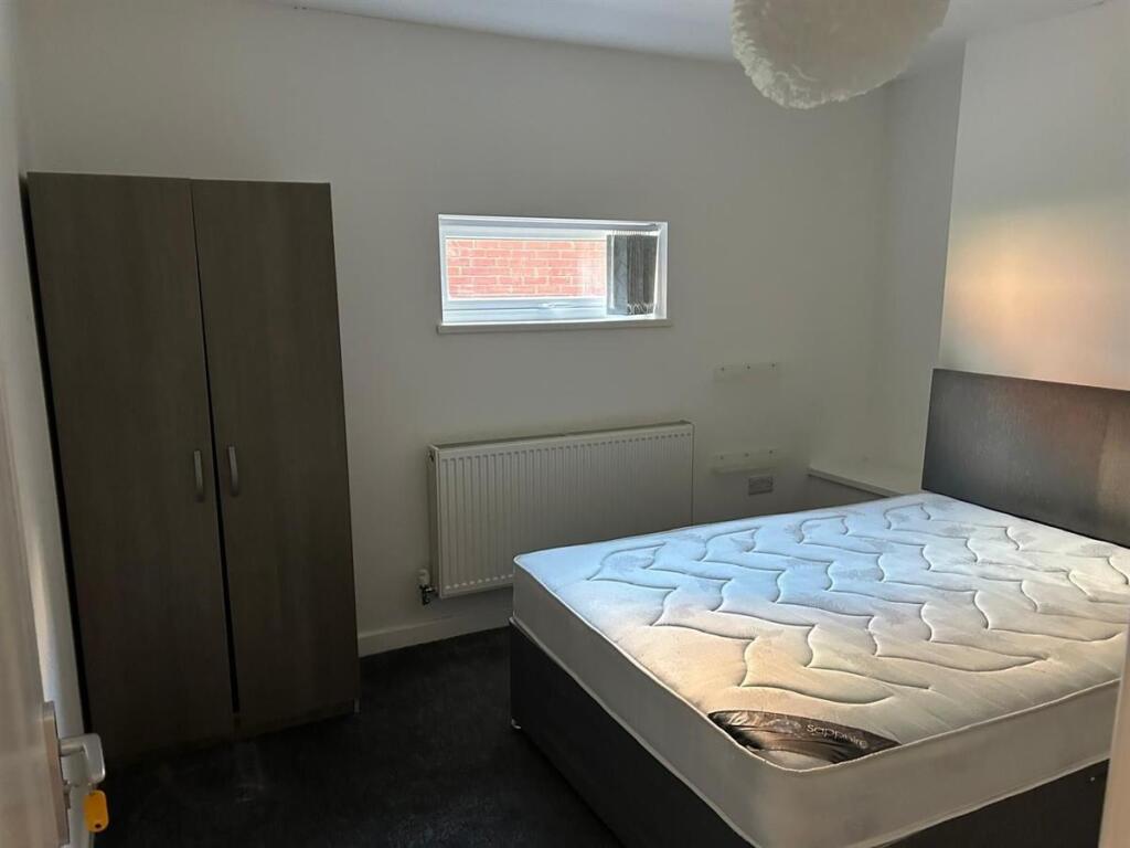 A tidy and modern double bedroom featuring a co...