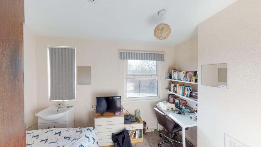 A bright and cozy single bedroom featuring a co...