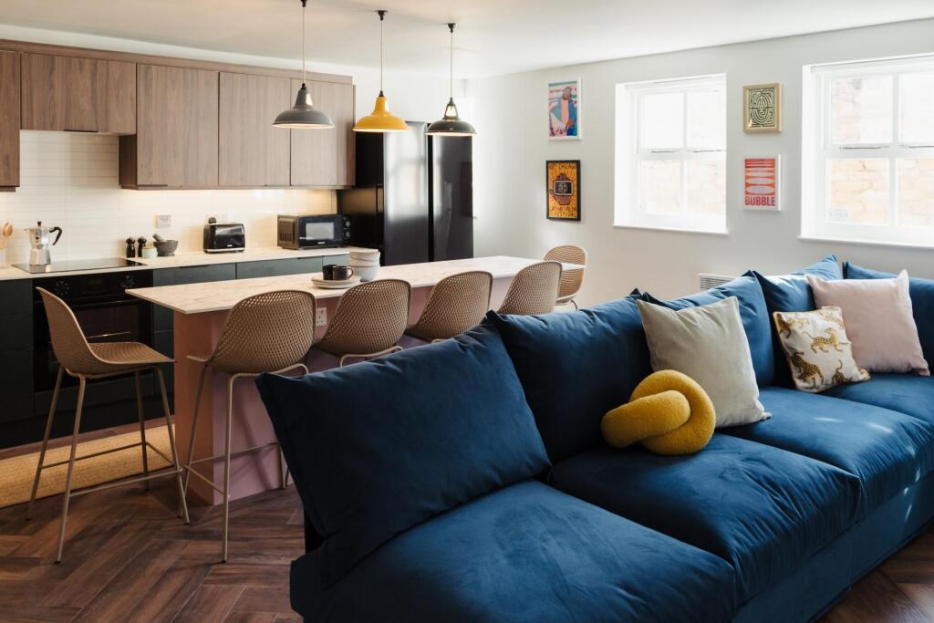 A spacious and modern living room featuring a c...