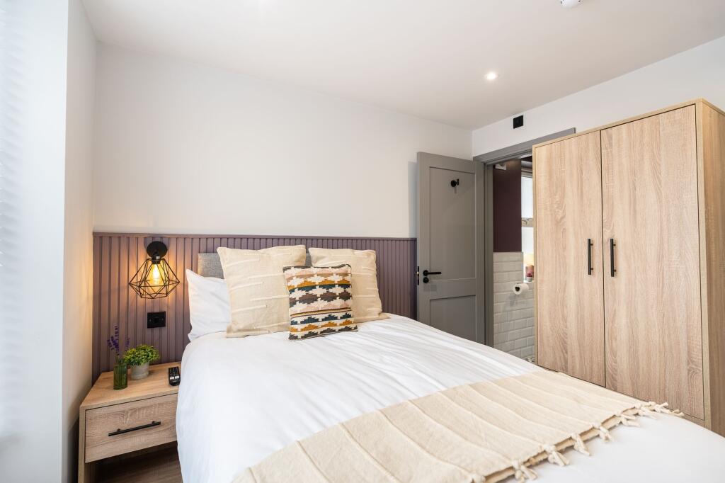 A cozy and well-decorated double bedroom featur...