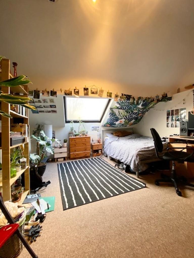 A cozy single bedroom with a comfortable bed, a...