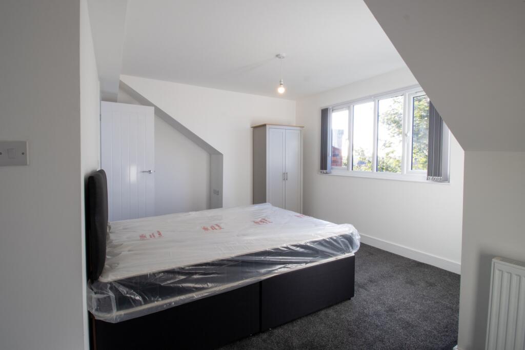 Bright and airy bedroom with a large window off...