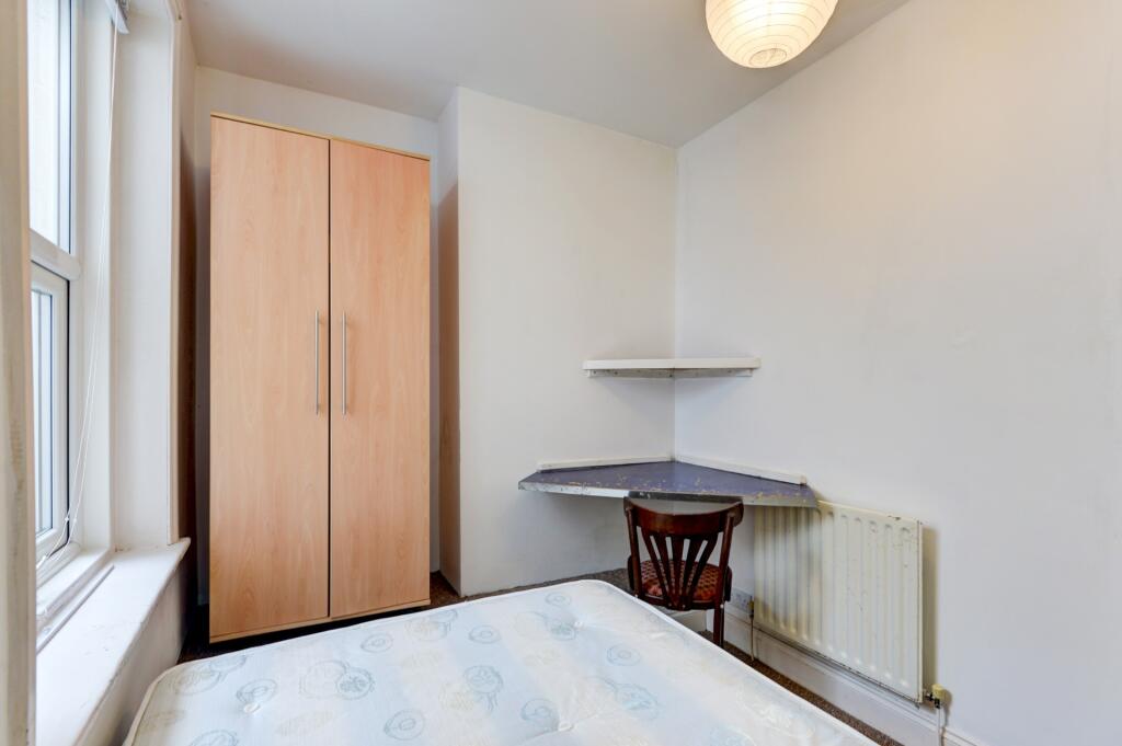 A cozy single bedroom featuring a comfortable b...