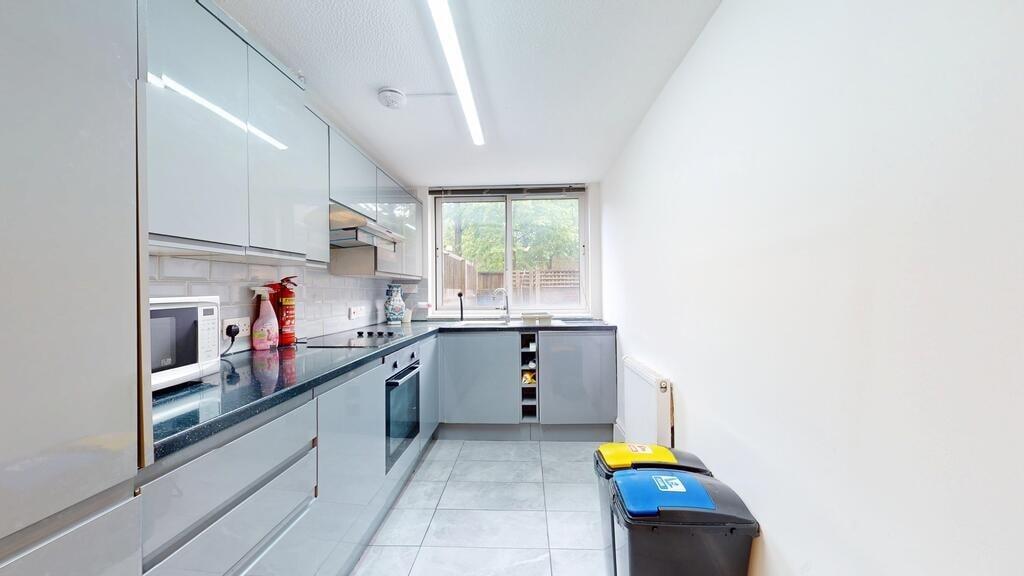 A modern, bright kitchen with sleek grey cabine...