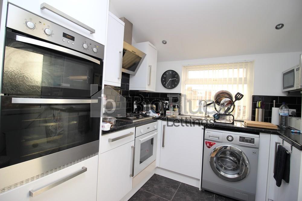 Bright and modern kitchen featuring built-in do...